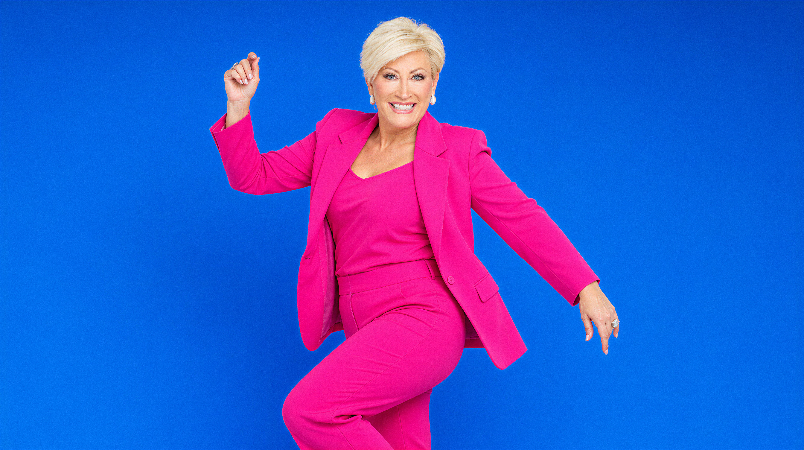 Kim Gravel mid-dance in a hot pink suit